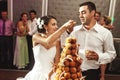 Happy married couple eating delicious chocolate wedding cake at Royalty Free Stock Photo