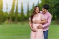 Happy married couple is expecting a baby. man embraces his pregnant wife in park Royalty Free Stock Photo
