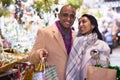 Happy married couple with gifts at new year street fair