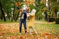 Happy married Couple having fun together outdoor in the golden autumn park, throwing leaves and laughing. Wife and husband in love Royalty Free Stock Photo