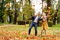 Happy married Couple having fun together outdoor in the golden autumn park, throwing leaves and laughing. Wife and husband in love Royalty Free Stock Photo