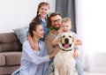 Happy married couple playing with their favorite pet dog   at home Royalty Free Stock Photo