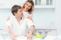 Happy married couple are preparing dinner in the kitchen and smiling. Husband and wife are preparing a birthday cake