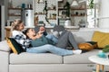 Happy married homosexual female gay couple laughing and embracing on the sofa with smile on their faces. Lesbian couple at home