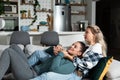 Happy married homosexual female gay couple laughing and embracing on the sofa with smile on their faces. Lesbian couple at home