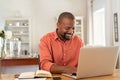 Happy mature black man using laptop