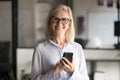 Happy mature business leader woman in elegant glasses holding phone Royalty Free Stock Photo