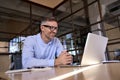 Happy mature business man looking at laptop having virtual meeting in office. Royalty Free Stock Photo