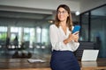 Happy mature business woman executive holding cell phone looking away in office. Royalty Free Stock Photo