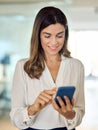 Happy mature business woman holding cellphone, using cell phone in office. Royalty Free Stock Photo