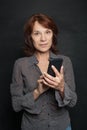 Happy mature businesswoman with smartphone. Royalty Free Stock Photo