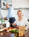 Happy mature couple cooking Spaniard tomatoes