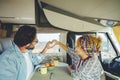 Happy mature couple doing heart gesture sign with hands together inside modern camper van vehicle. Concept of traveler and road Royalty Free Stock Photo