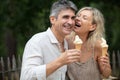 happy mature couple eating ice cream in park Royalty Free Stock Photo