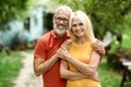 Happy Mature Couple Embracing While Standing Outdoors In Their Garden Royalty Free Stock Photo