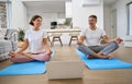 Happy mature couple learning online yoga class on computer meditating at home. Royalty Free Stock Photo