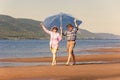 Happy and mature couple in love walk along the sandy bank of the river on a summer sunny day Royalty Free Stock Photo