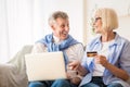 Happy mature couple making online purchases on laptop Royalty Free Stock Photo