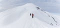 Senior couple is snowshoe hiking in alpine snow winter mountains panorama. Allgau, Bavaria, Germany. Royalty Free Stock Photo