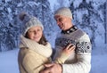 Happy mature couple, man 60 years old and woman 55 years old are have fun, hugging in winter forest, early evening in park among Royalty Free Stock Photo