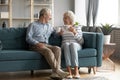 Happy mature couple relax on couch drinking tea Royalty Free Stock Photo
