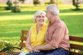 Happy mature couple sitting on bench in city park Royalty Free Stock Photo