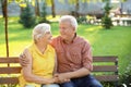 Happy mature couple sitting on bench in city park Royalty Free Stock Photo