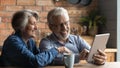 Happy mature couple using table device in kitchen Royalty Free Stock Photo