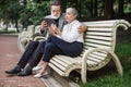 Happy mature couple using tablet while sitting at park Royalty Free Stock Photo