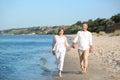 Happy mature couple walking at beach sunny day Royalty Free Stock Photo