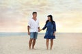 Happy mature couple walking  on sea beach at sunset Royalty Free Stock Photo