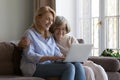 Happy mature daughter and elderly mother sharing laptop Royalty Free Stock Photo