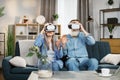 Happy mature family playing games at home and using VR glasses at home. Royalty Free Stock Photo