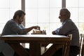 Happy mature father play chess with grownup son Royalty Free Stock Photo