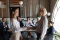 Happy mature female business leader shaking hand of new employee