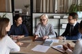 Happy mature female business leader talking to team, giving instructions Royalty Free Stock Photo