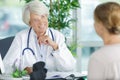 Happy mature female doctor talking to female patient Royalty Free Stock Photo