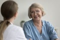 Happy mature female patient consulting doctor in office Royalty Free Stock Photo