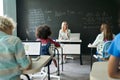 Happy mature female teacher teaching kids at maths class in junior school. Royalty Free Stock Photo