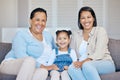 Happy mature grandmother relaxing with her granddaughter and adult daughter at home. Cheerful little hispanic girl Royalty Free Stock Photo