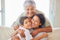 Happy mature grandmother relaxing with her grandson and adult daughter at home. Cheerful little hispanic boy sitting on Royalty Free Stock Photo