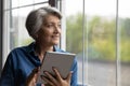 Happy modern mature woman using tablet gadget Royalty Free Stock Photo