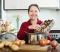 Happy mature housewife holding dried mushrooms Royalty Free Stock Photo