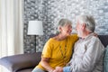 Happy mature husband and wife sit rest on couch at home hugging and cuddling, show care affection, smiling senior loving couple Royalty Free Stock Photo