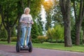 Happy mature lady driving segway