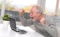 Happy mature man having a good surprise on laptop Royalty Free Stock Photo