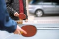 Happy mature man and his son playing table tennis outdoor during quarentine because of COVID 19, coronavirus