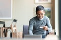 Happy mature man holding credit card paying online by using laptop for payment. Royalty Free Stock Photo