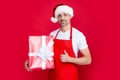happy mature man in new year hat and red apron hold present Royalty Free Stock Photo