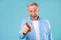 Happy mature man pointing fingers at camera at studio Royalty Free Stock Photo